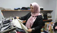 Kadın muhtar mahallelinin hem derdini dinliyor hem terziliğini yapıyor