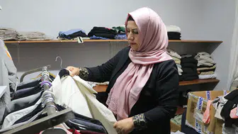 Kadın muhtar mahallelinin hem derdini dinliyor hem terziliğini yapıyor
