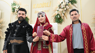 Bir çift nikah masasına geleneksel kıyafetlerle oturdu